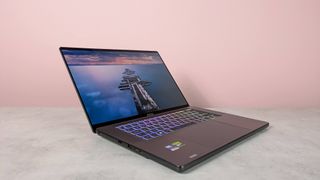 Three-quarter view of MSI Stealth 16 AI+ open on a white desk with pink wall in background